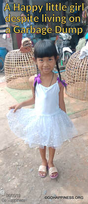 Happy little girl on a garbage dump near Bangkok